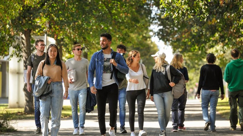 Studierende laufen auf dem Campus