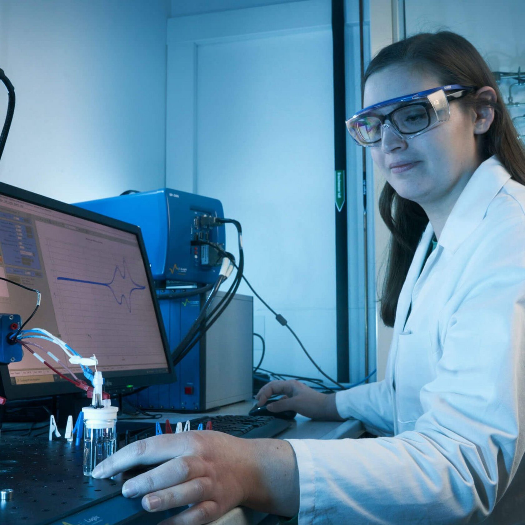 Studierende hat eine Schutzbrille auf und macht eine Probe im Labor.