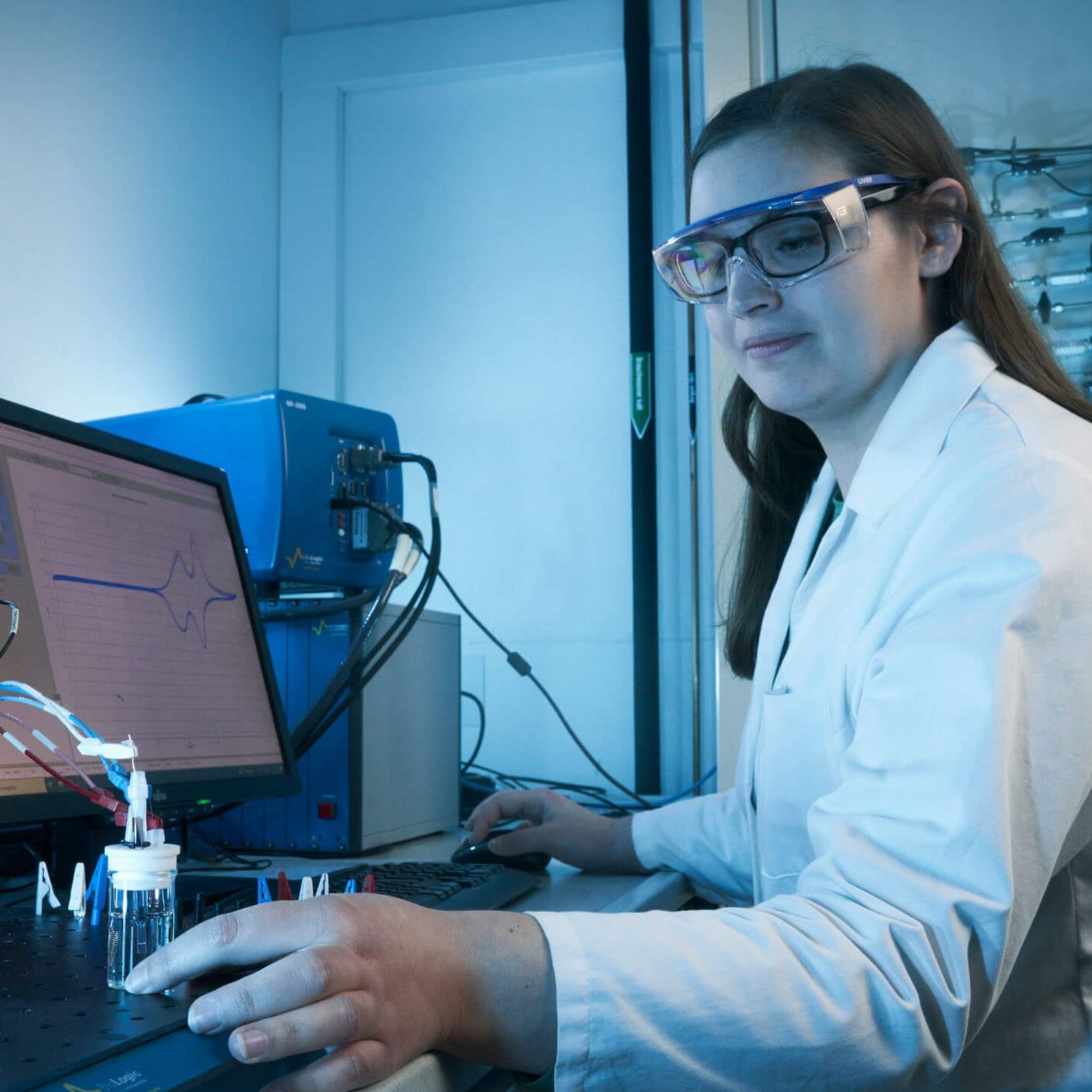 Studierende hat eine Schutzbrille auf und macht eine Probe im Labor.