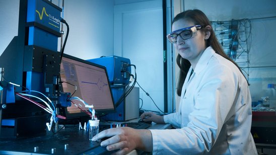 Studierende hat eine Schutzbrille auf und macht eine Probe im Labor.